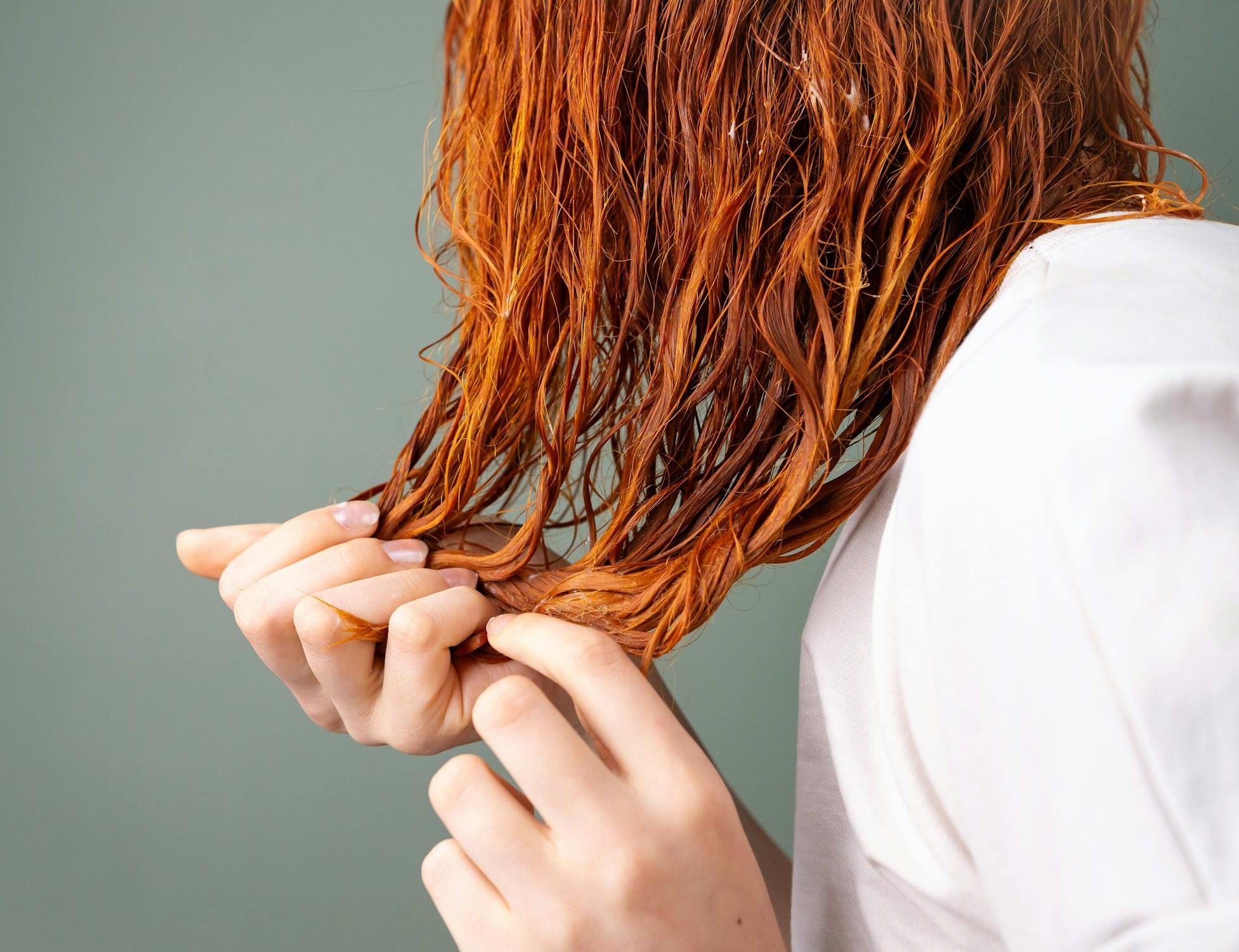 free photo of gros plan sur les cheveux roux et les mains sous un eclairage doux